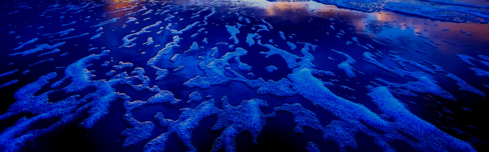 Aerial view of vibrant blue ocean waters with coral reefs.